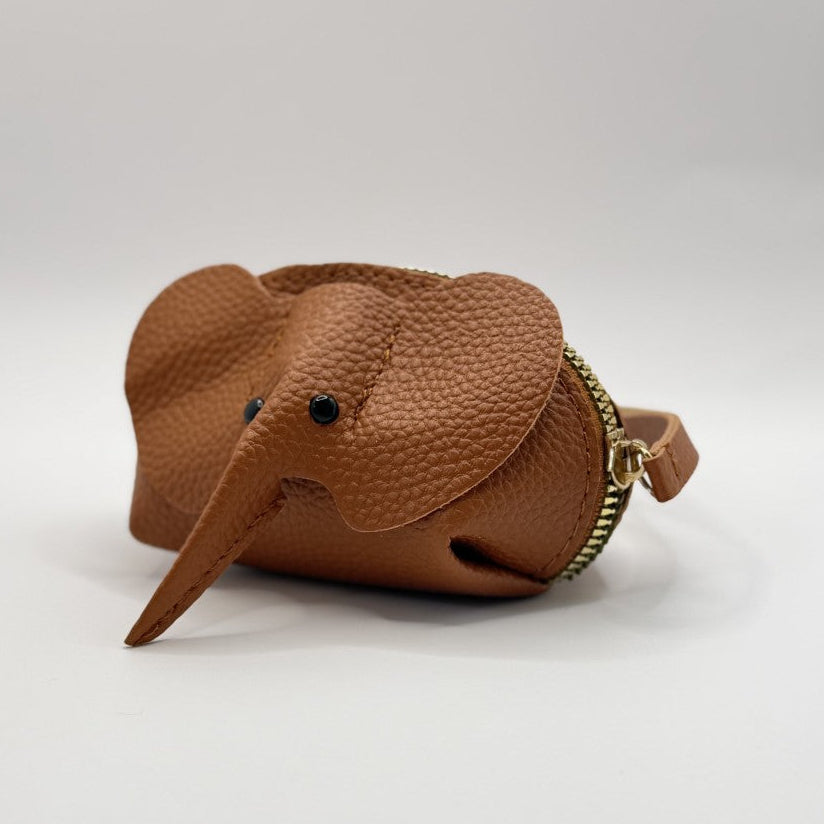A small brown faux-leather elephant-shaped coin purse with a pebbled texture, black bead eyes, and a gold-tone zipper, shown on a light gray studio background.